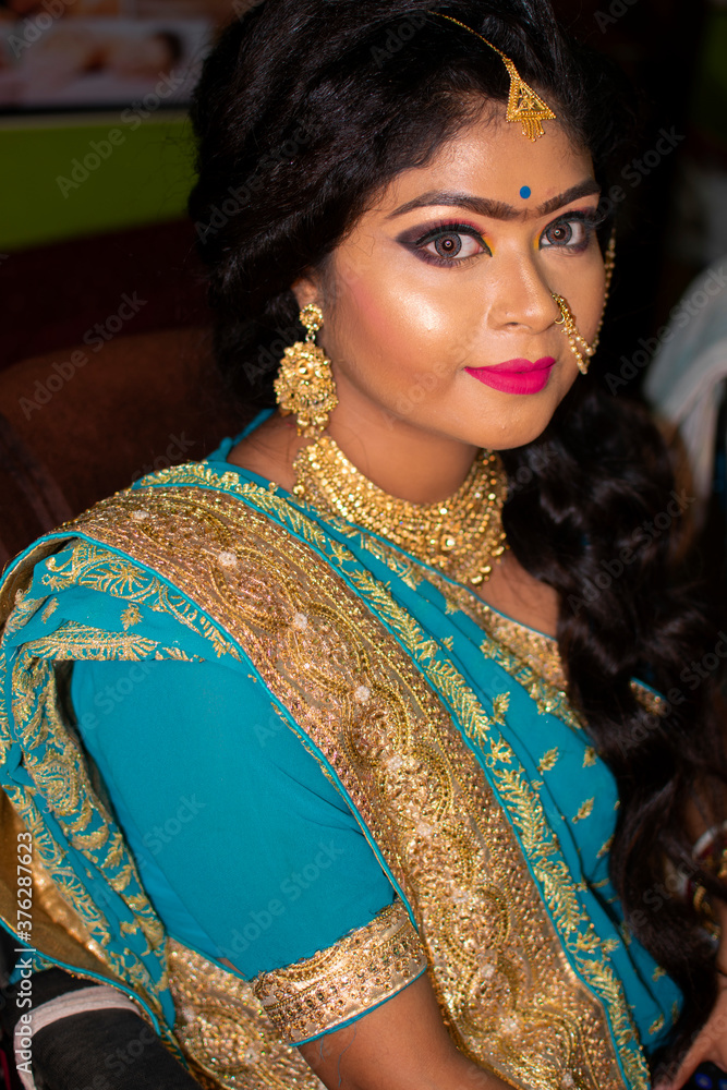 an indian teenage girl happy with indian ethnic wear and ornaments in a marriage reception party
