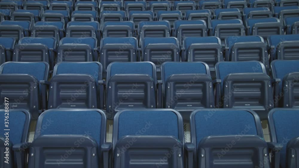 Blue seats on an empty big hockey stadium. Camera moves up on tripod Blue seats on an empty big hockey stadium. Camera moves up on tripod