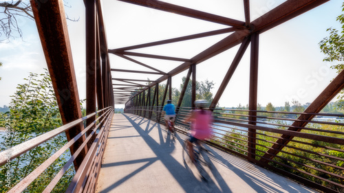  Cyclers ride across a scenic bridge above the Boise River photo