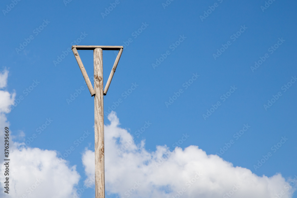 wooden pylon with an V at the end, blue sky in the background wooden pylon with an V at the end, blue sky in the background