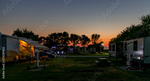 Motorhome and trailers parked in a Rv park at sunset on a beautiful evening 