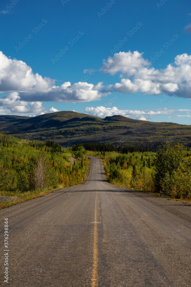 Fototapeta premium Scenic Road View of Klondike Hwy during a sunny and cloudy day. Taken near Whitehorse, Yukon, Canada.