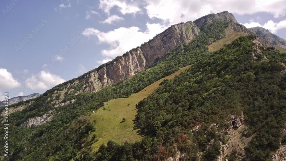Picturesque scenery. Mountain against cloudy sky. Clouds floating on blue sky over mountain ridge. Picturesque scenery. Mountain against cloudy sky. Clouds floating on blue sky over mountain ridge.