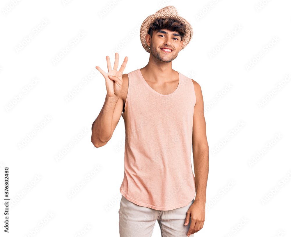 Young hispanic man wearing summer hat showing and pointing up with fingers number four while smiling confident and happy. Young hispanic man wearing summer hat showing and pointing up with fingers number four while smiling confident and happy.