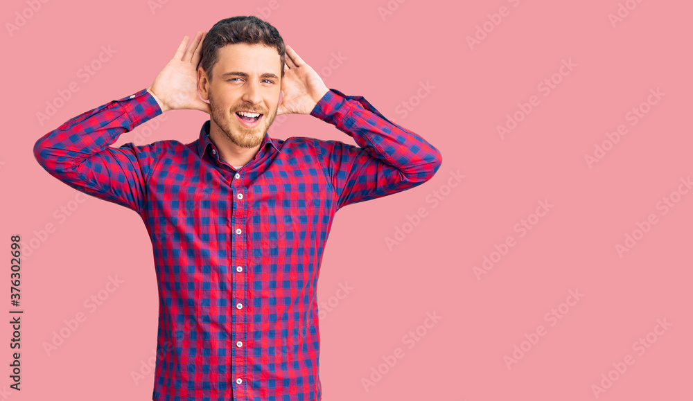 Handsome young man with bear wearing casual shirt smiling cheerful playing peek a boo with hands showing face. surprised and exited Handsome young man with bear wearing casual shirt smiling cheerful playing peek a boo with hands showing face. surprised and exited