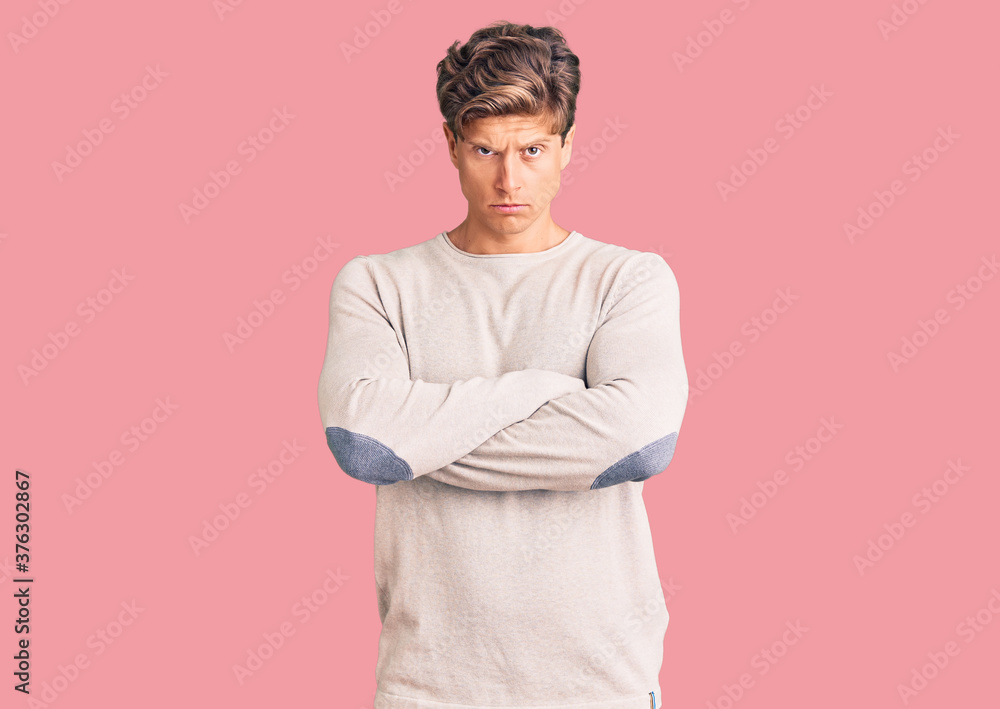 Young handsome man wearing casual clothes skeptic and nervous, disapproving expression on face with crossed arms. negative person. Young handsome man wearing casual clothes skeptic and nervous, disapproving expression on face with crossed arms. negative person.