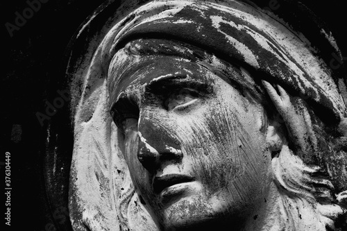 Virgin Mary. Fragment of amcient statue of sad woman in grief photo