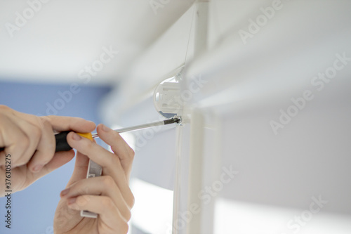 Man installing cassette roller blinds on windows