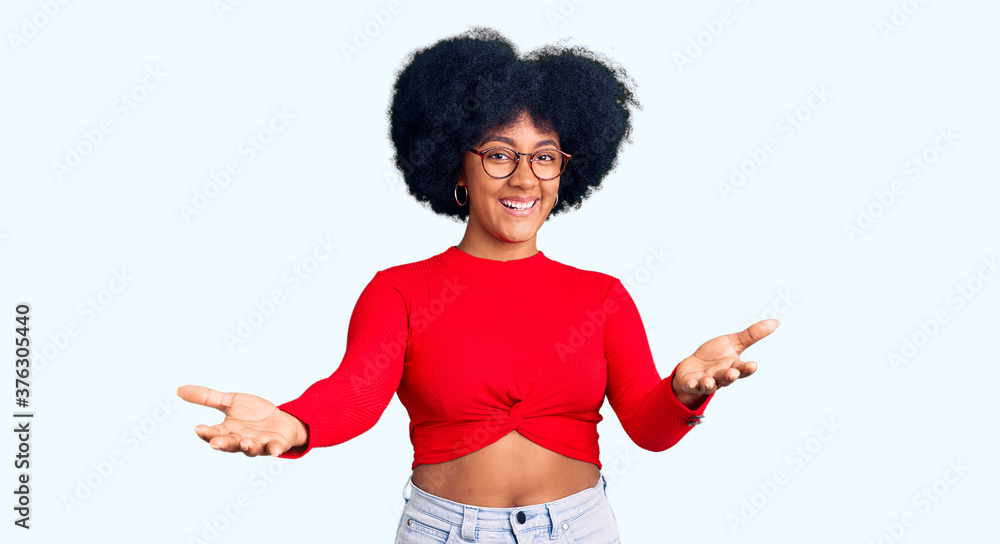 Young african american girl wearing casual clothes and glasses smiling cheerful offering hands giving assistance and acceptance. Young african american girl wearing casual clothes and glasses smiling cheerful offering hands giving assistance and acceptance.