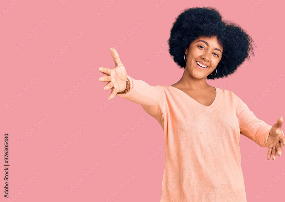Young african american girl wearing casual clothes looking at the camera smiling with open arms for hug. cheerful expression embracing happiness. Young african american girl wearing casual clothes looking at the camera smiling with open arms for hug. cheerful expression embracing happiness.