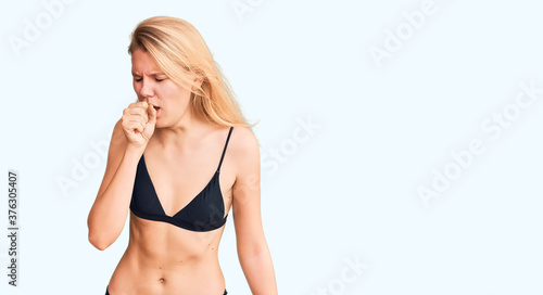 Young beautiful blonde woman wearing bikini feeling unwell and coughing as symptom for cold or bronchitis. health care concept. © Krakenimages.com