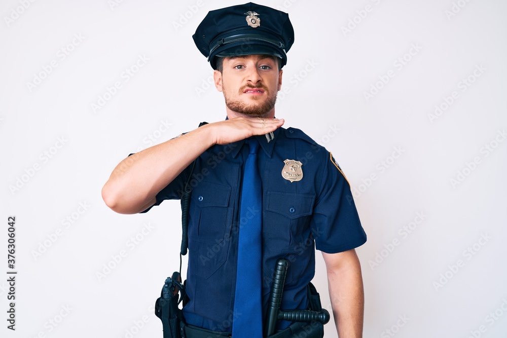 Young caucasian man wearing police uniform cutting throat with hand as knife, threaten aggression with furious violence Young caucasian man wearing police uniform cutting throat with hand as knife, threaten aggression with furious violence
