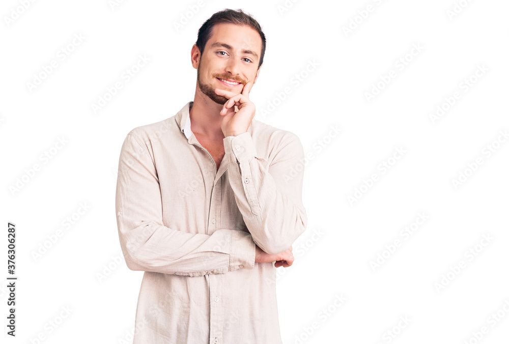 Young handsome caucasian man wearing casual clothes looking confident at the camera with smile with crossed arms and hand raised on chin. thinking positive. Young handsome caucasian man wearing casual clothes looking confident at the camera with smile with crossed arms and hand raised on chin. thinking positive.