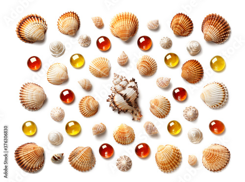 Pattern made of shells and yellow and orange glass pebbles isolated on white background