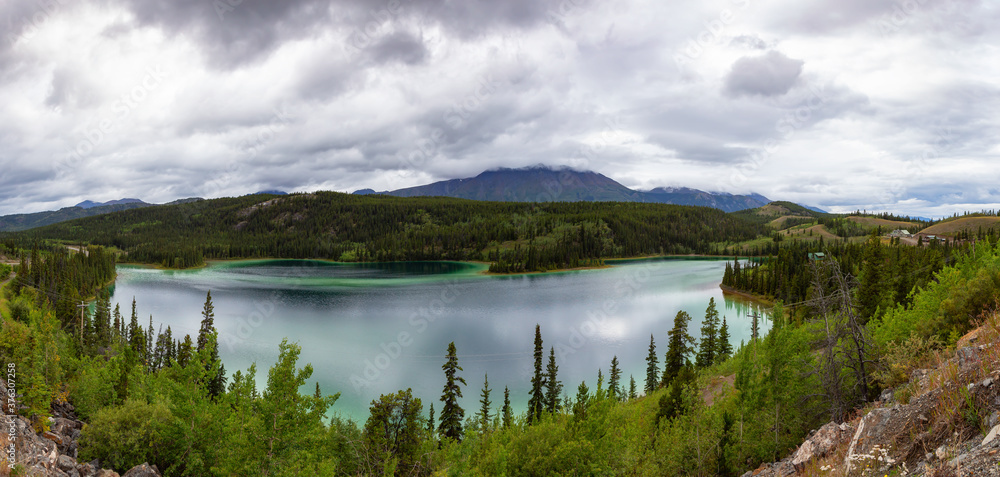 Panoramic Beautiful View of Emerald Lake during a cloudy summer day. Located near Whitehorse, Carcross, Yukon, Canada. Nature Background Panorama Panoramic Beautiful View of Emerald Lake during a cloudy summer day. Located near Whitehorse, Carcross, Yukon, Canada. Nature Background Panorama