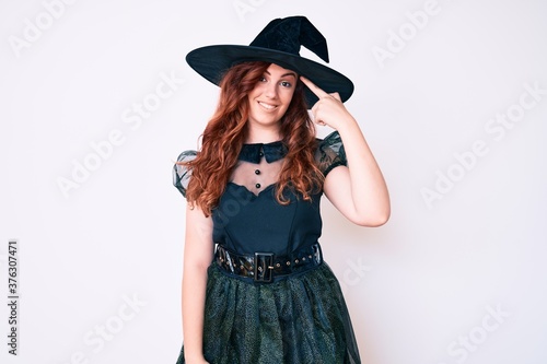 Young beautiful woman wearing witch halloween costume smiling pointing to head with one finger, great idea or thought, good memory © Krakenimages.com
