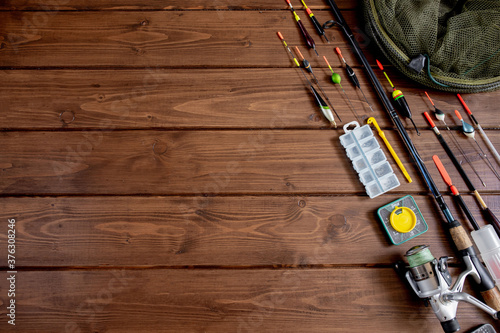 fishing tackle - fishing rod fishing float and accessories on wooden background, copy space.