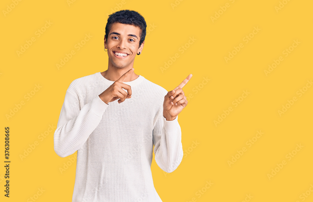 Young african amercian man wearing casual clothes smiling and looking at the camera pointing with two hands and fingers to the side. Young african amercian man wearing casual clothes smiling and looking at the camera pointing with two hands and fingers to the side.