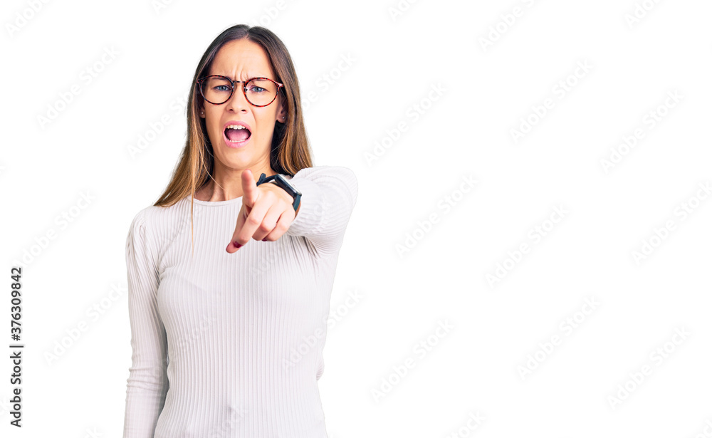 Beautiful brunette young woman wearing casual white sweater and glasses pointing displeased and frustrated to the camera, angry and furious with you Beautiful brunette young woman wearing casual white sweater and glasses pointing displeased and frustrated to the camera, angry and furious with you