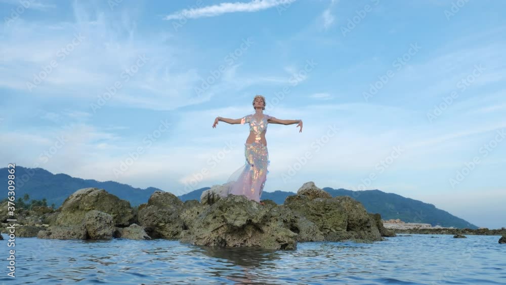Magical fairy posing on a rocky sea shore