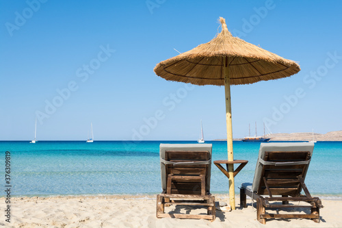 Two beach chairs and an umbrella on the beach © respiro888
