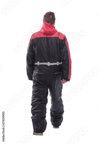 man in a winter insulated jumpsuit reading walking forward