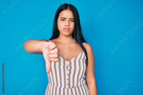Young beautiful asian girl wearing casual clothes looking unhappy and angry showing rejection and negative with thumbs down gesture. bad expression. © Krakenimages.com
