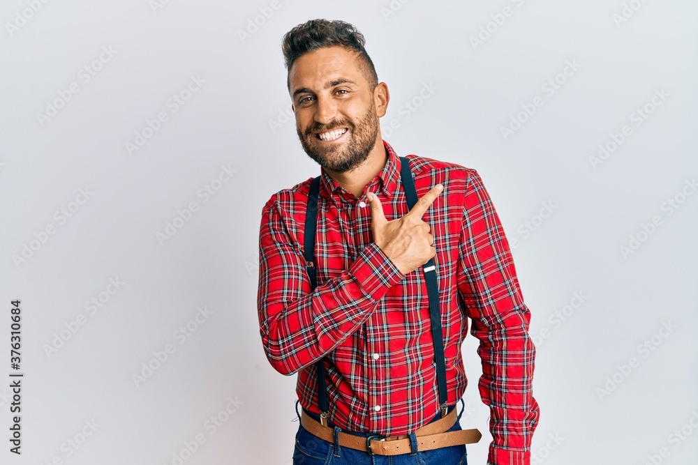 Handsome man with beard wearing hipster elegant look cheerful with a smile of face pointing with hand and finger up to the side with happy and natural expression on face