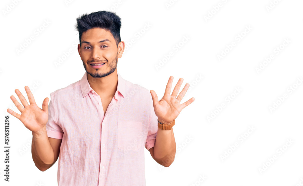 Handsome latin american young man wearing casual summer shirt showing and pointing up with fingers number ten while smiling confident and happy. Handsome latin american young man wearing casual summer shirt showing and pointing up with fingers number ten while smiling confident and happy.