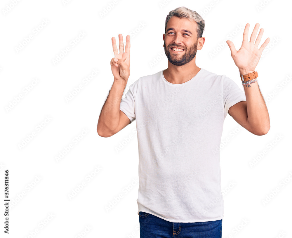 Naklejka premium Young handsome blond man wearing casual t-shirt showing and pointing up with fingers number eight while smiling confident and happy.