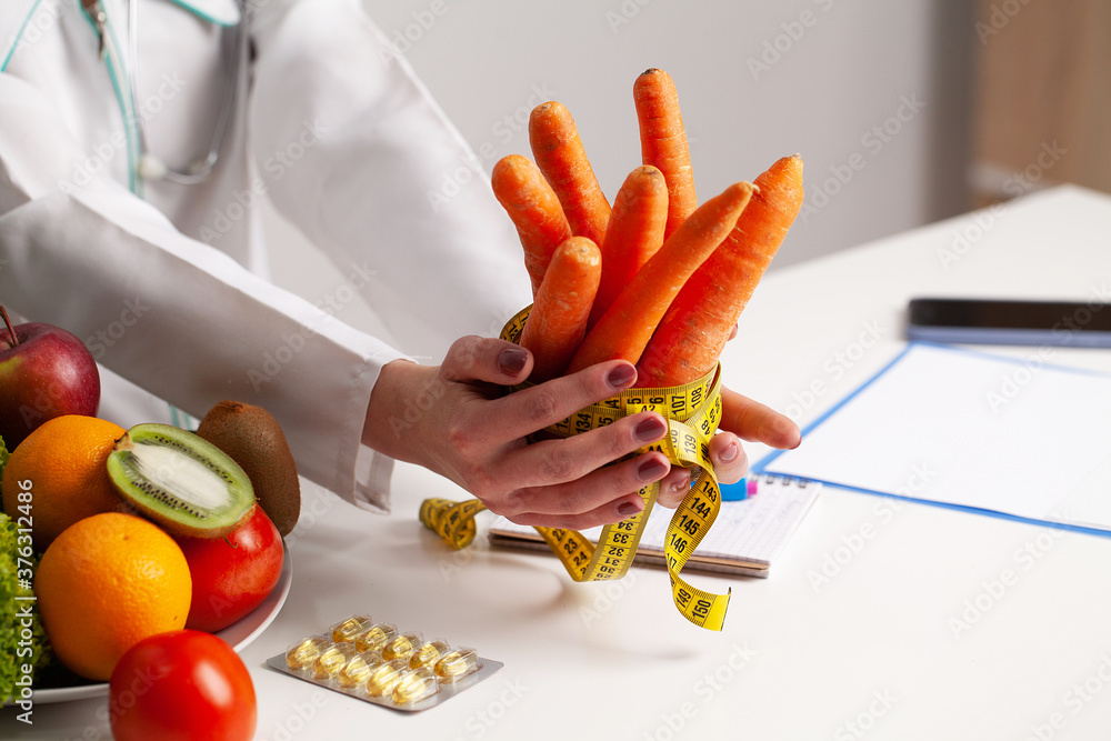 Closeup of woman holding carrot with string tape to measure. Closeup of woman holding carrot with string tape to measure.