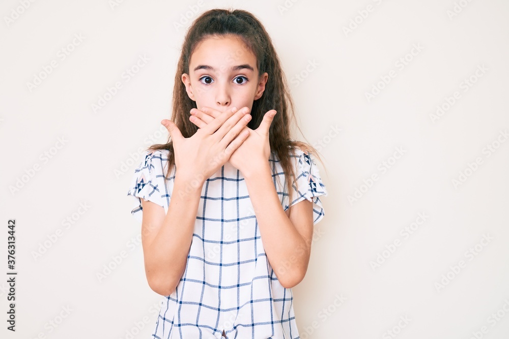 Cute hispanic child girl wearing casual clothes shocked covering mouth with hands for mistake. secret concept. Cute hispanic child girl wearing casual clothes shocked covering mouth with hands for mistake. secret concept.