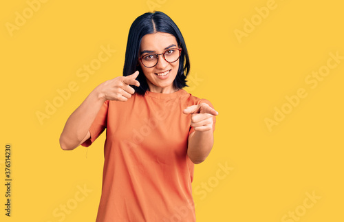 Young beautiful latin woman wearing casual clothes pointing fingers to camera with happy and funny face. good energy and vibes. © Krakenimages.com