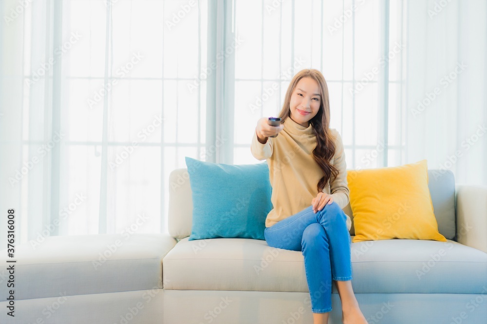 Portrait beautiful young asian woman with remote tv on sofa Portrait beautiful young asian woman with remote tv on sofa