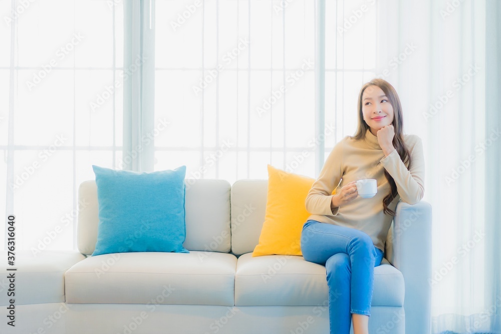 Portrait beautiful young asian woman with coffee cup on sofa decoration