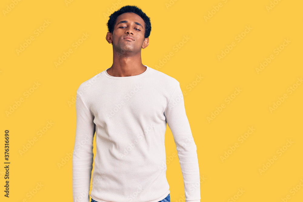 African handsome man wearing casual winter sweater relaxed with serious expression on face. simple and natural looking at the camera. African handsome man wearing casual winter sweater relaxed with serious expression on face. simple and natural looking at the camera.