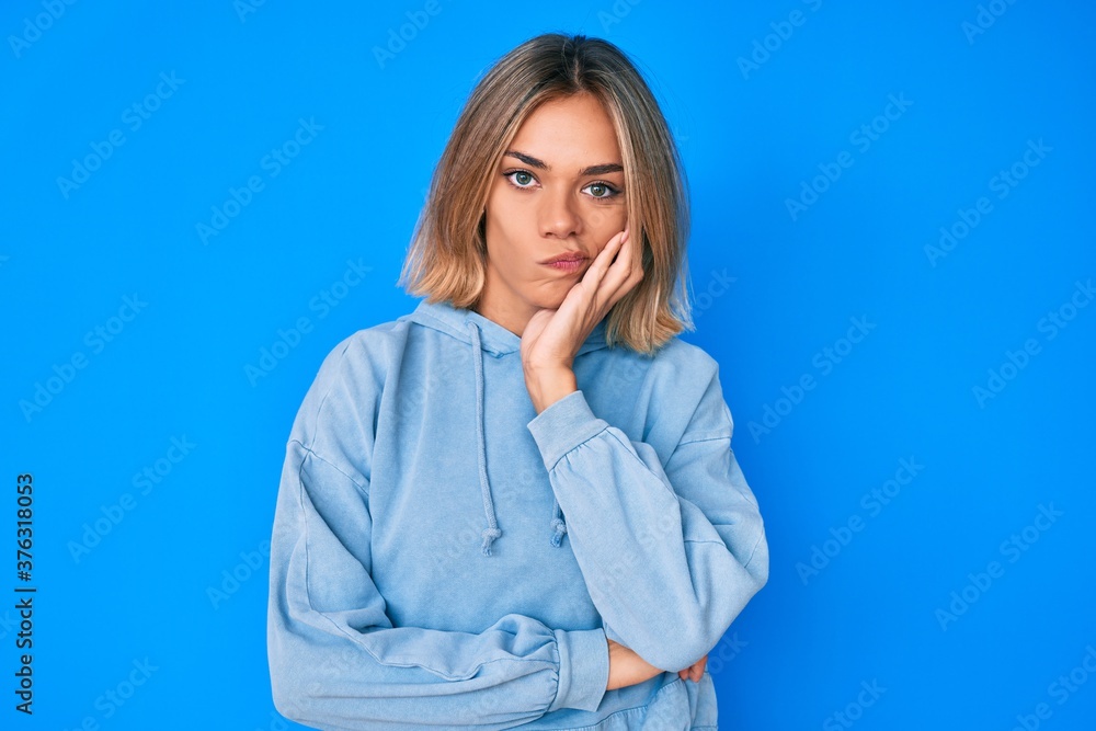 Beautiful caucasian woman wearing casual sweatshirt thinking looking tired and bored with depression problems with crossed arms. Beautiful caucasian woman wearing casual sweatshirt thinking looking tired and bored with depression problems with crossed arms.