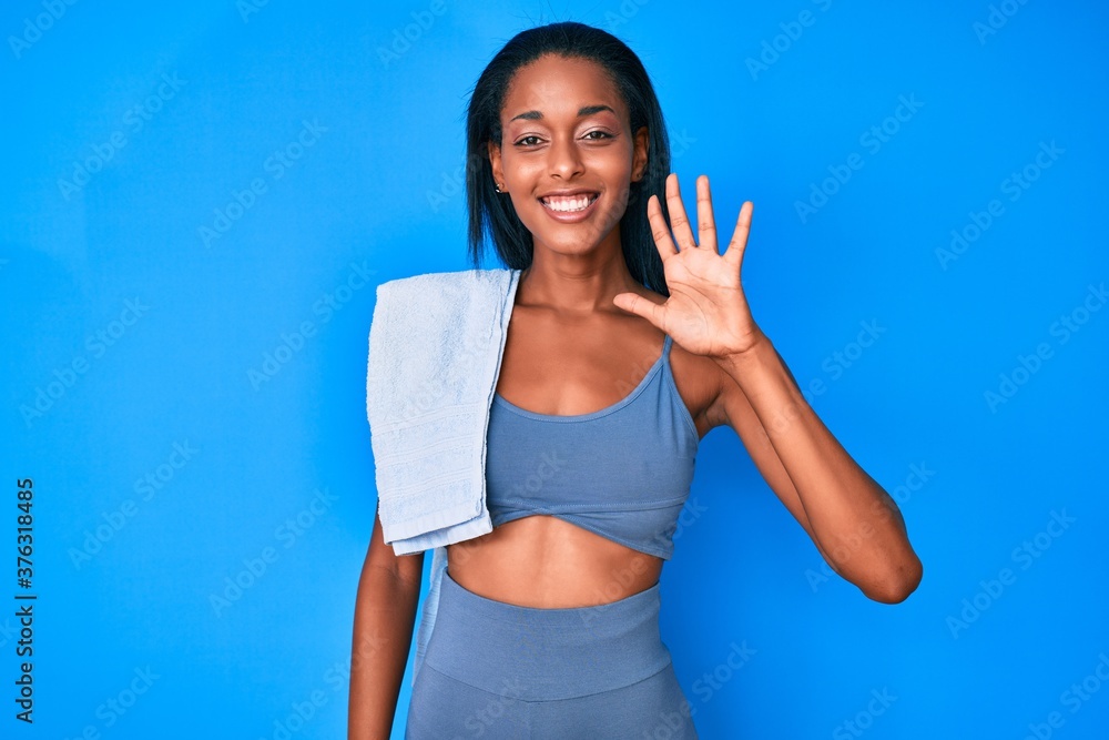 Young african american woman wearing sportswear showing and pointing up with fingers number five while smiling confident and happy. Young african american woman wearing sportswear showing and pointing up with fingers number five while smiling confident and happy.