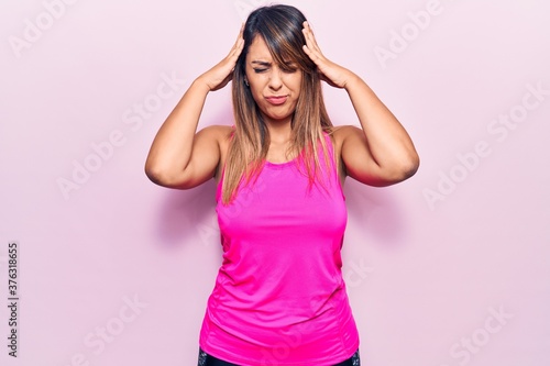 Young beautiful woman wearing sportswear with hand on head  headache because stress. suffering migraine.