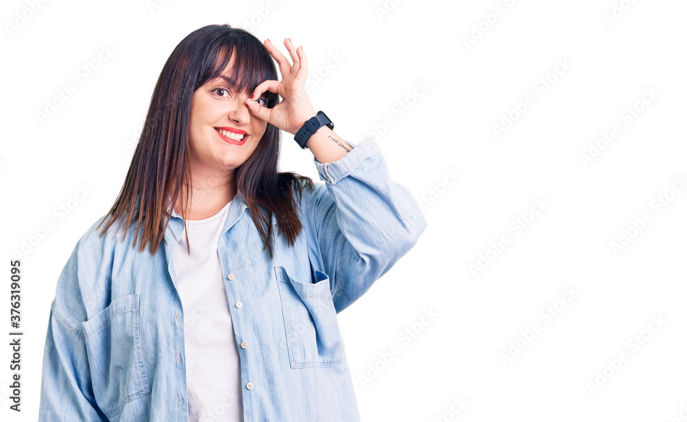 Young plus size woman wearing casual clothes smiling happy doing ok sign with hand on eye looking through fingers Young plus size woman wearing casual clothes smiling happy doing ok sign with hand on eye looking through fingers