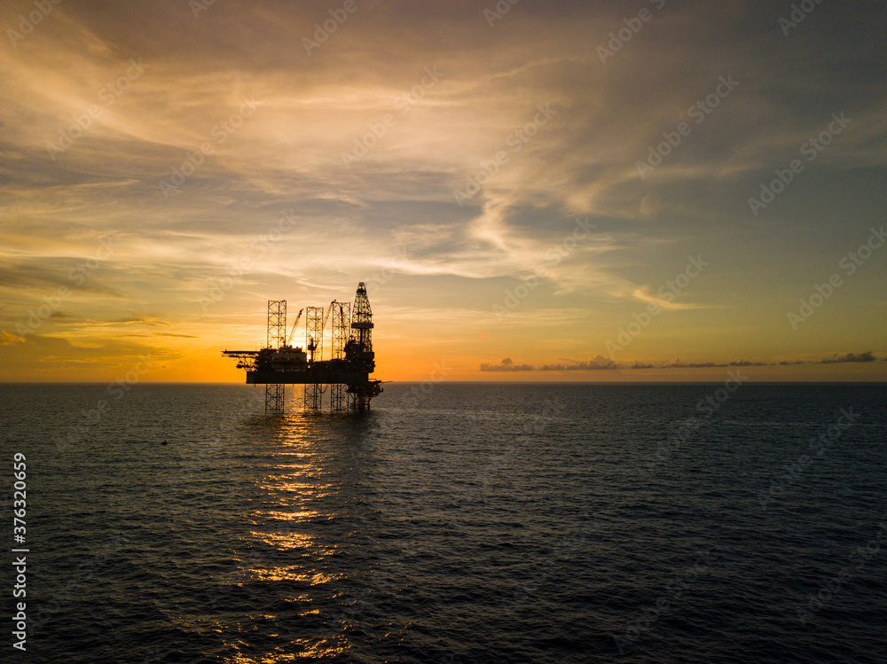 Aerial view from a drone of an offshore jack up rig at the offshore location during sunset time