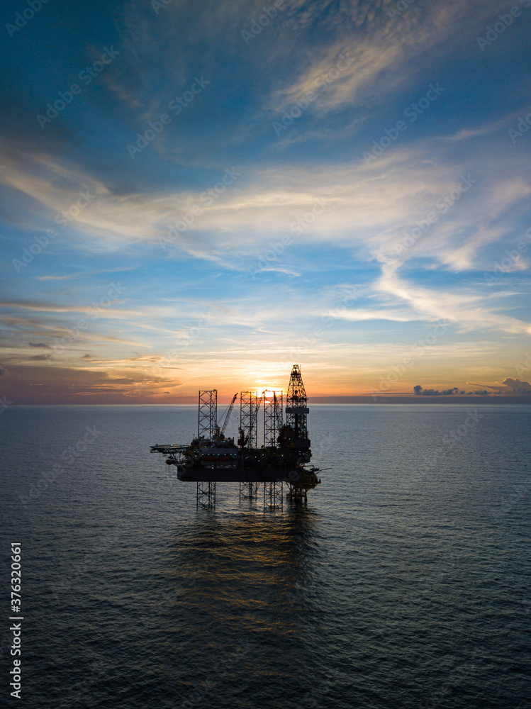 Aerial view from a drone of an offshore jack up rig at the offshore location during sunset time