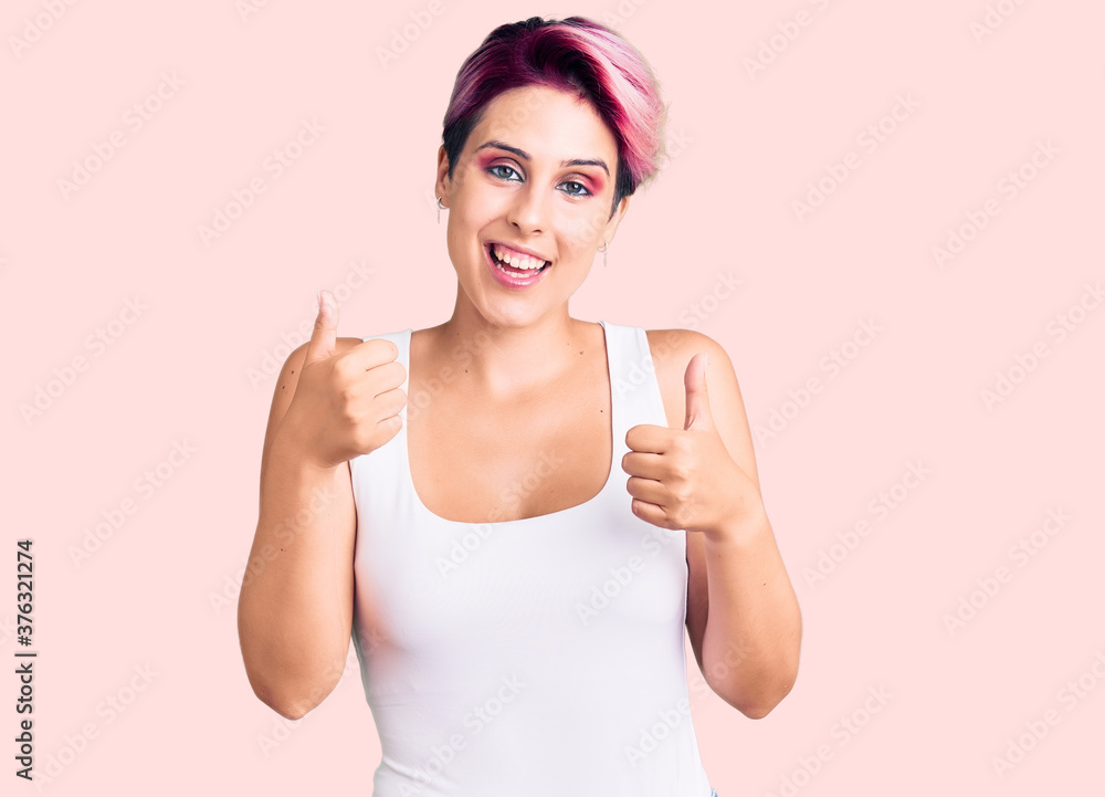 Young beautiful woman with pink hair wearing casual clothes success sign doing positive gesture with hand, thumbs up smiling and happy. cheerful expression and winner gesture. Young beautiful woman with pink hair wearing casual clothes success sign doing positive gesture with hand, thumbs up smiling and happy. cheerful expression and winner gesture.