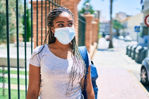 Young african american student woma wearing coronavirus safety mask at the university campus photo