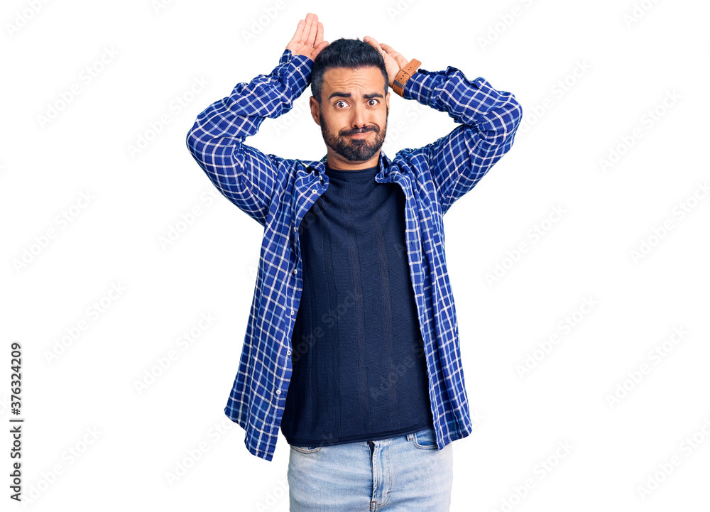 Young hispanic man wearing casual clothes doing bunny ears gesture with hands palms looking cynical and skeptical. easter rabbit concept. Young hispanic man wearing casual clothes doing bunny ears gesture with hands palms looking cynical and skeptical. easter rabbit concept.