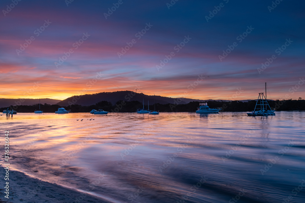 Naklejka premium Sunset at the waterfront with high cloud and boats