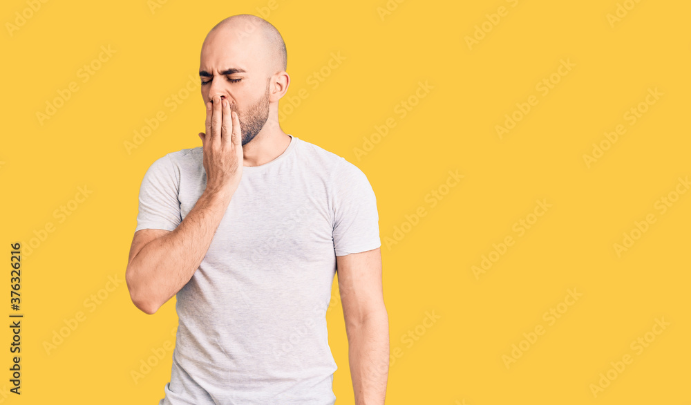 Young handsome man wearing casual t shirt bored yawning tired covering mouth with hand. restless and sleepiness. Young handsome man wearing casual t shirt bored yawning tired covering mouth with hand. restless and sleepiness.