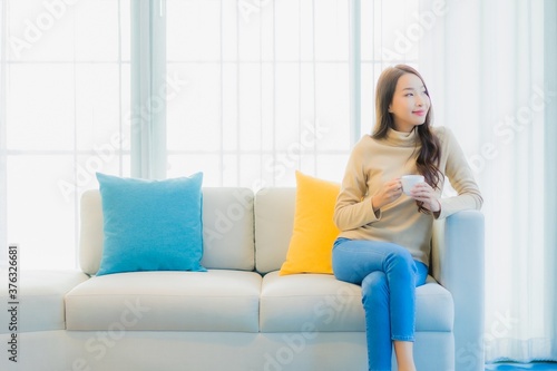 Portrait beautiful young asian woman with coffee cup on sofa decoration