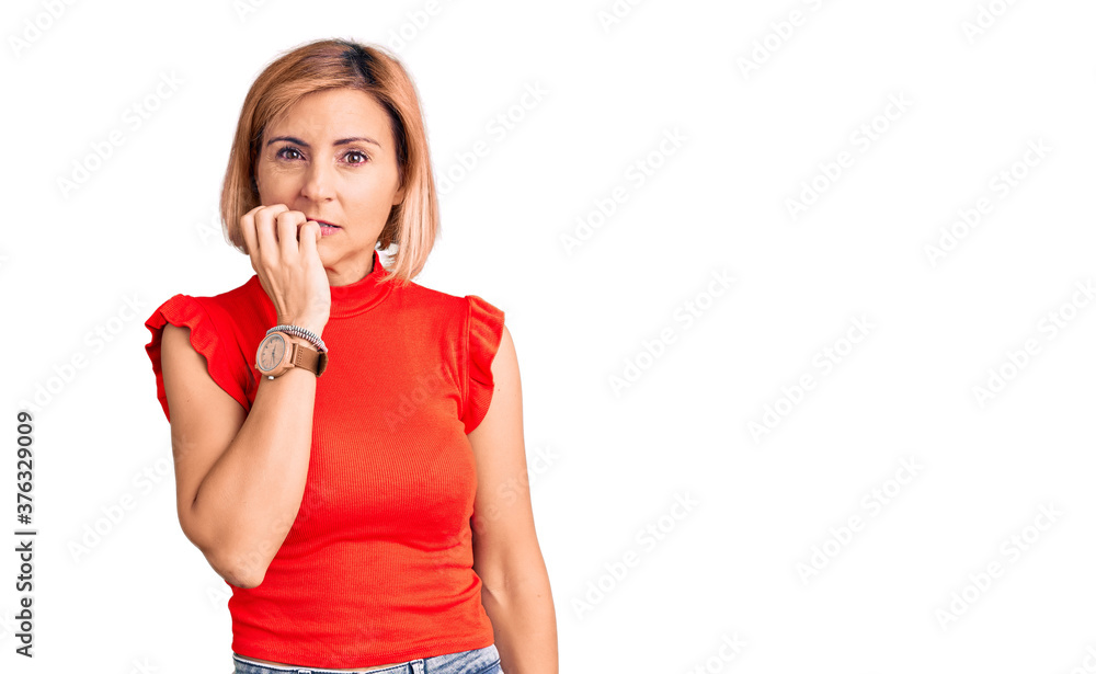Young blonde woman wearing casual clothes looking stressed and nervous with hands on mouth biting nails. anxiety problem. Young blonde woman wearing casual clothes looking stressed and nervous with hands on mouth biting nails. anxiety problem.
