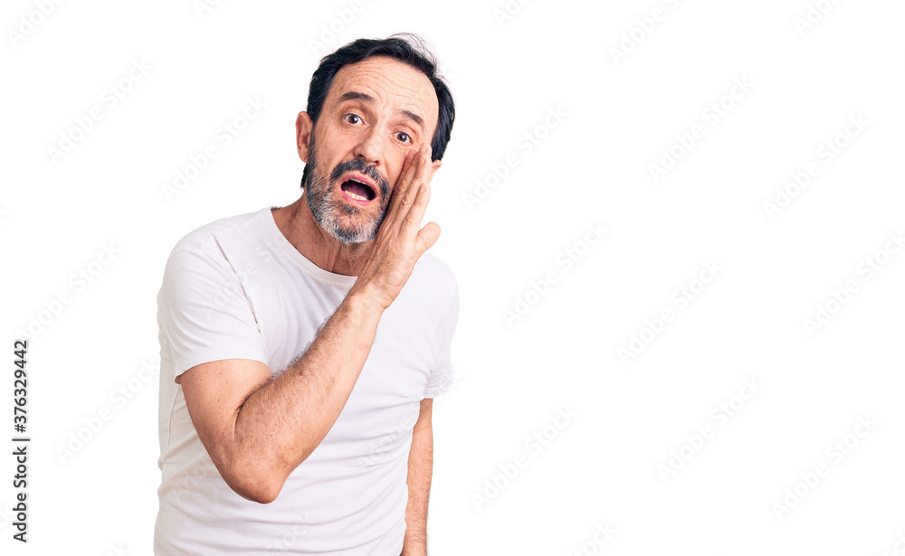 Middle age handsome man wearing casual t-shirt hand on mouth telling secret rumor, whispering malicious talk conversation Middle age handsome man wearing casual t-shirt hand on mouth telling secret rumor, whispering malicious talk conversation
